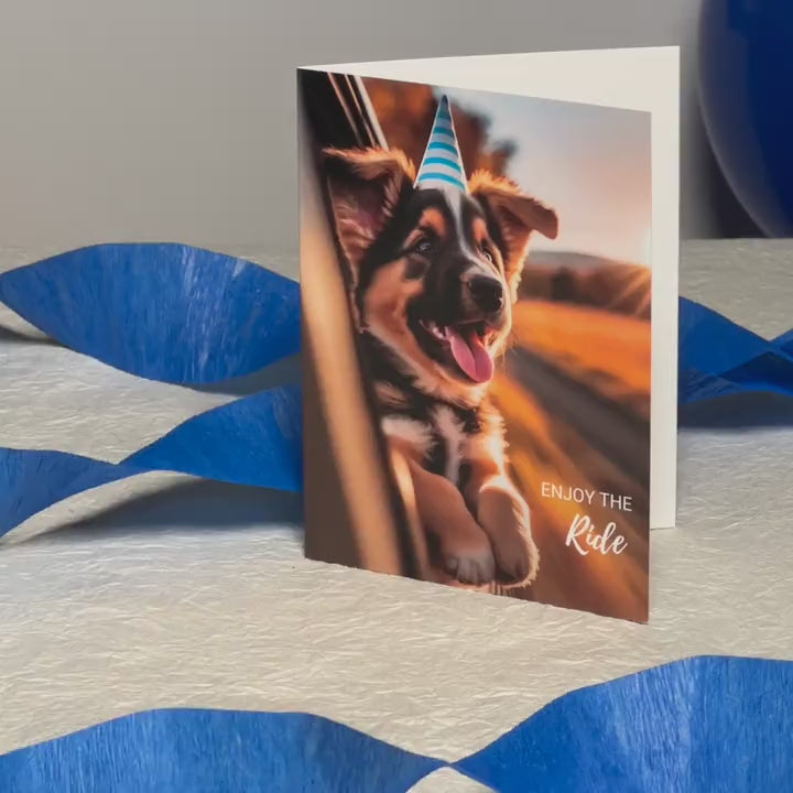 Augmented reality birthday card featuring a German Shepherd poking out the window of a car and wearing a party hat